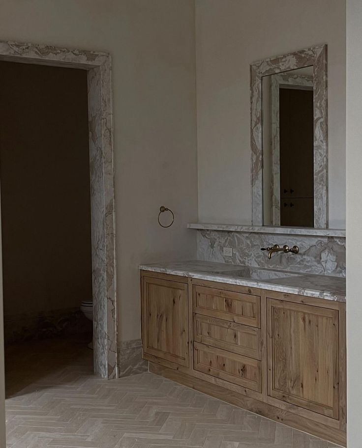 an empty bathroom with two sinks and mirrors