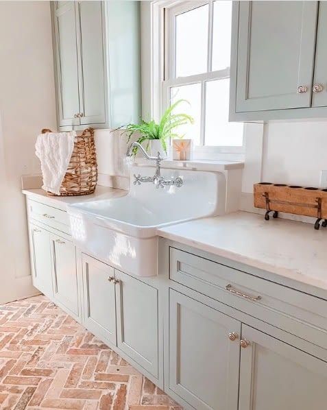 a white sink sitting under a window in a bathroom