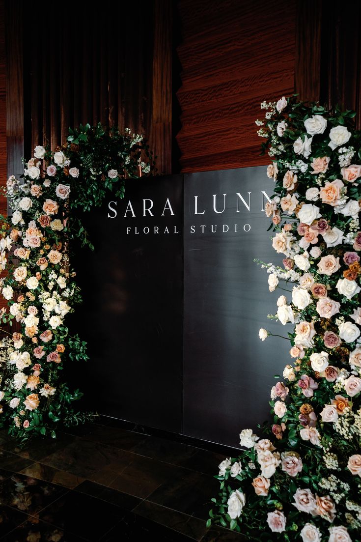 the entrance to sara luna floral studio is decorated with roses and greenery for an elegant wedding