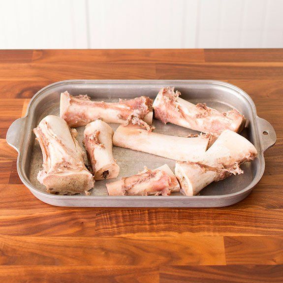 raw chicken legs in a pan on a wooden table