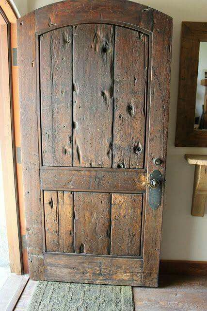 an old wooden door in the corner of a room with a rug on the floor