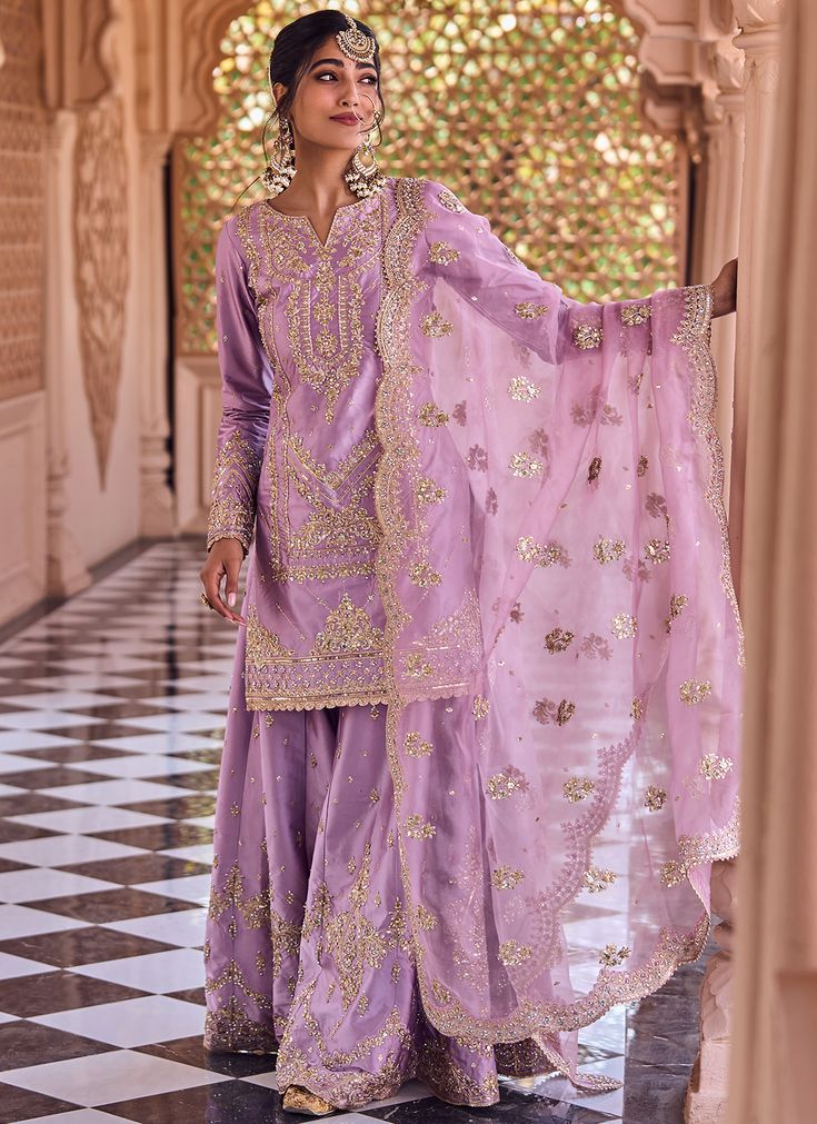 Our Dusty Purple Embroidered Sharara includes a satin top, santoon bottom, and an organza dupatta. Embroidery is present on this style using zari, thread, stone, and hand work.  Like all of our pieces, this piece is made in India and checked by hand to ensure high quality. Festive Organza Palazzo Set With Intricate Embroidery, Dola Silk Palazzo Set With Zari Work For Reception, Gold Chanderi Palazzo Set With Intricate Embroidery, Unstitched Dola Silk Palazzo Set For Reception, Reception Dola Silk Salwar Kameez With Dupatta, Dola Silk Salwar Kameez With Dupatta For Reception, Festive Organza Palazzo Set For Reception, Bollywood Style Tissue Silk Palazzo Set For Reception, Tissue Silk Salwar Kameez With Dupatta For Reception