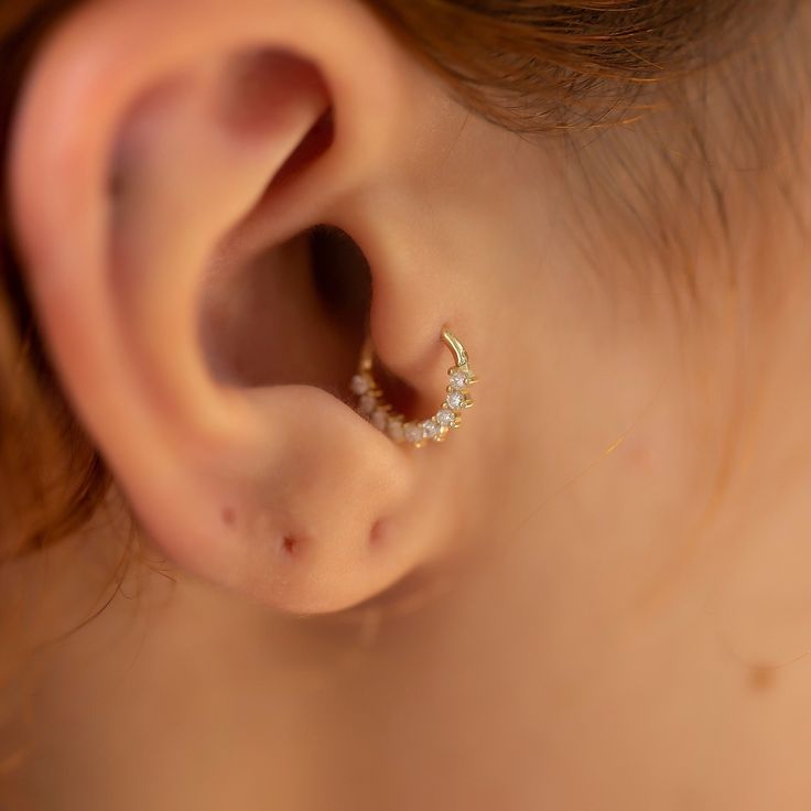 a close up of a person's ear with a ring on top of it