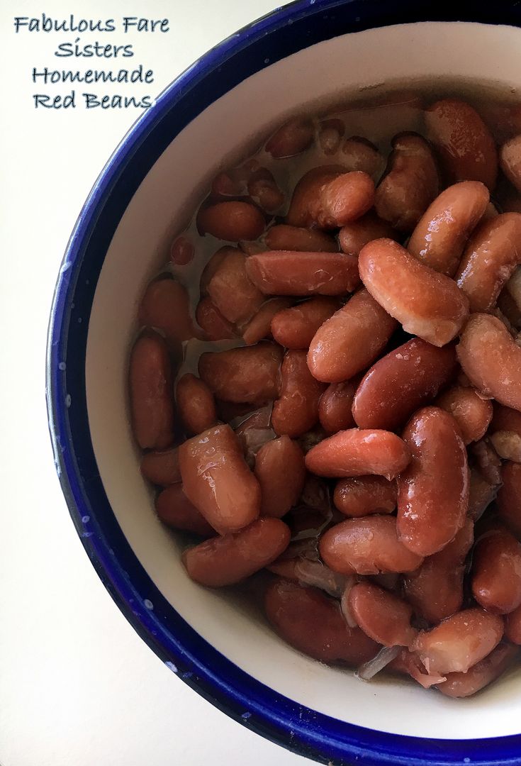 a bowl filled with lots of beans on top of a white table next to a blue plate