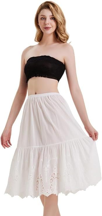 a woman wearing a white skirt and black top