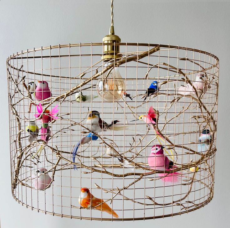 a chandelier made out of wire with colorful birds on the branches hanging from it