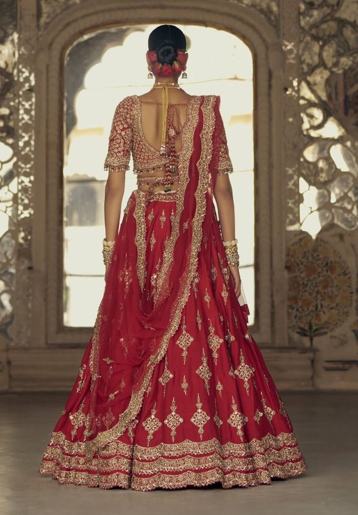 Make a striking impression in this red raw silk lehenga choli, complemented by a net dupatta embroidered in gold dori and highlighted with dabka, beads, sequins, and crystals. It comes with a second beige dupatta and belt. Embroidered Bridal Lehenga, Raw Silk Lehenga, Anamika Khanna, Diana Penty, Red Lehenga, Indian Wedding Wear, Sonakshi Sinha, Tarun Tahiliani, Sara Ali Khan