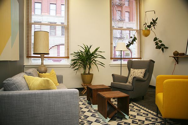 a living room filled with furniture next to two windows