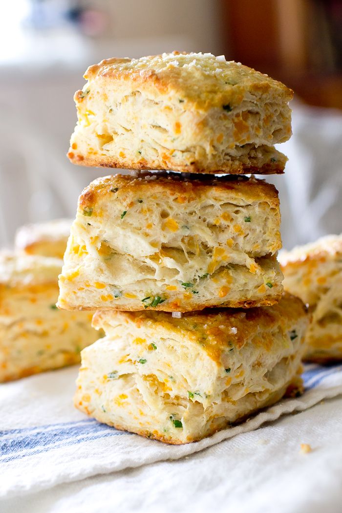 four biscuits stacked on top of each other with cheese sprinkled on the edges