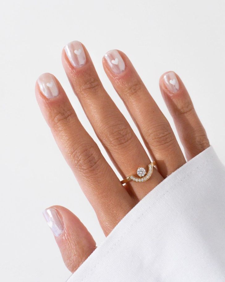 a woman's hand wearing a gold ring with a diamond on the middle finger