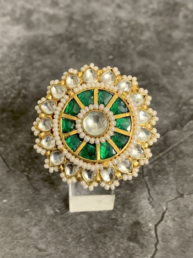 Adjustable pachi Kundan finger ring. Gold plated and foil work. 1.75 inch in diameter. White color seed bead work all round. Traditional Green Rings, Chandbali Rings For Festivals, Handmade Temple Jewelry Style Round Ring, Festive Meenakari Temple Jewelry Ring, Festive Temple Jewelry Rings With Meenakari, Festive Meenakari Rings, Handmade Temple Jewelry Ring For Festive Occasion, Festive Handmade Temple Jewelry Ring, Festive Kundan Rings With Stone Setting