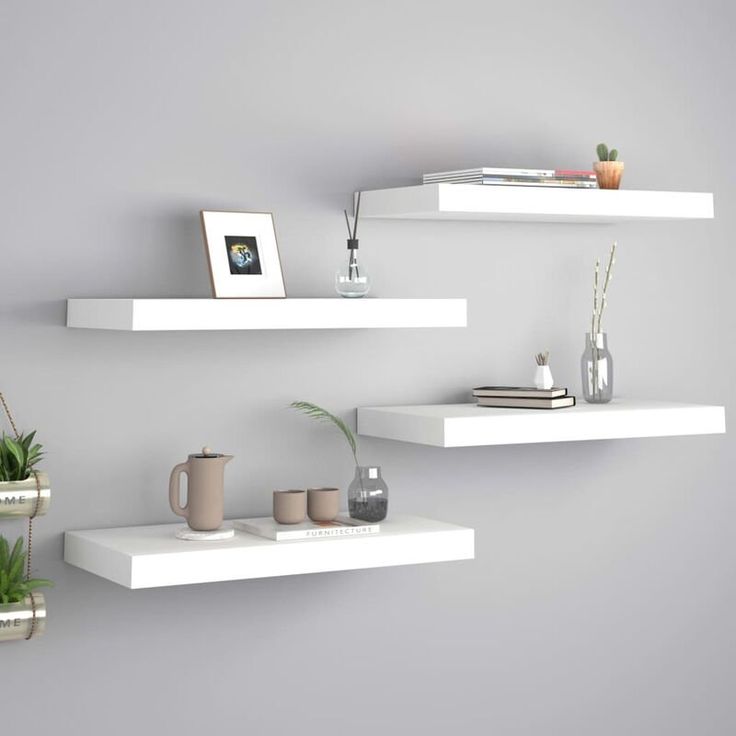 two white shelves with plants and books on them