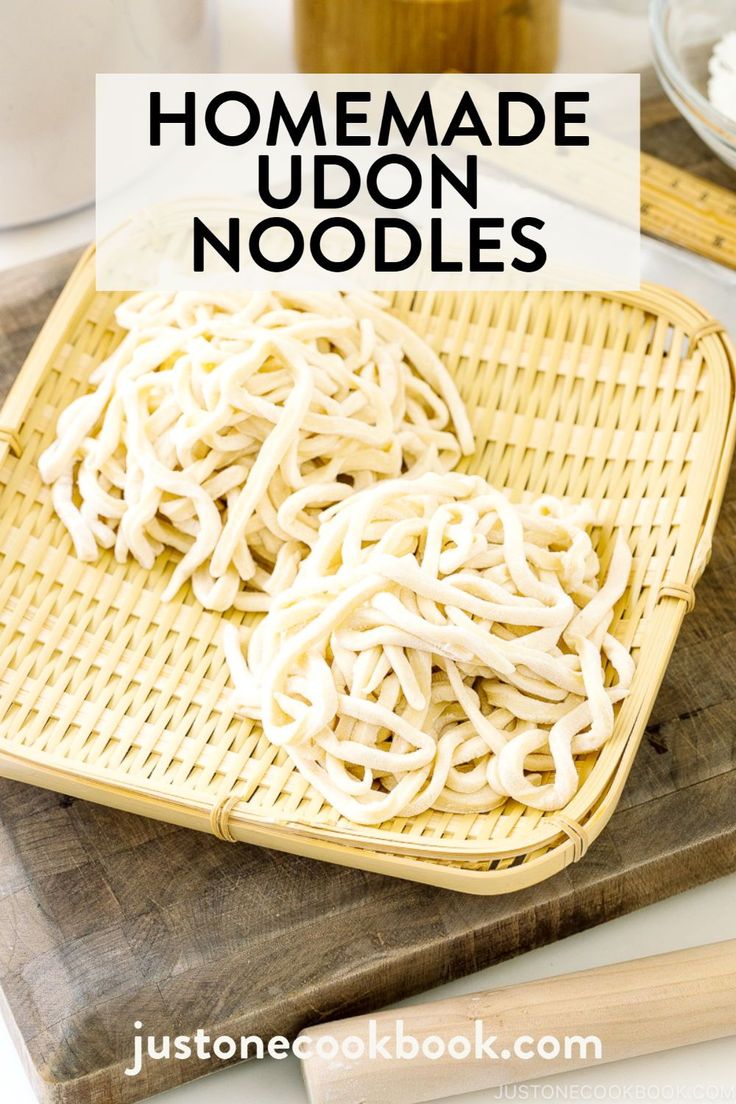 homemade udon noodles in a basket on a cutting board