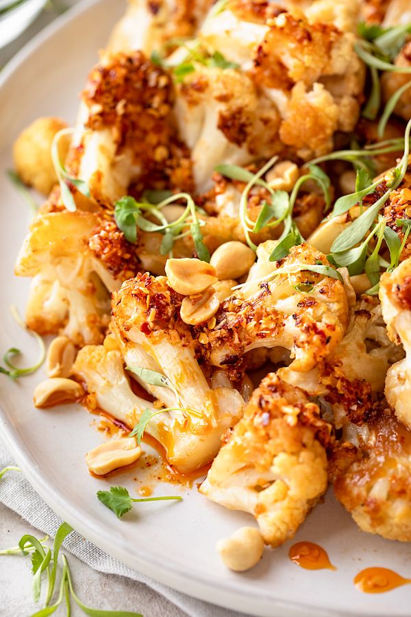 a white plate topped with cauliflower covered in seasoning