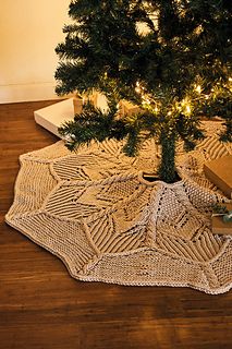 a small christmas tree is on the floor next to some presents and a box that has been wrapped in twine