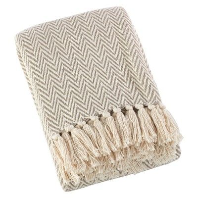 a beige and white blanket with fringes