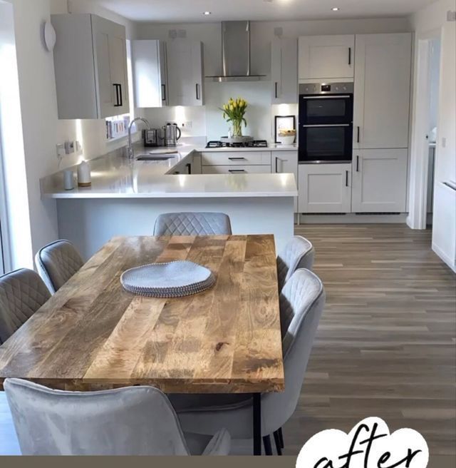 a kitchen with a wooden table surrounded by chairs