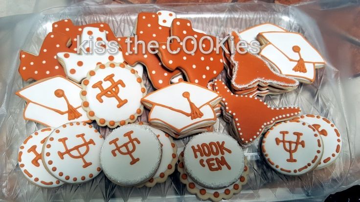 cookies decorated with orange and white icing are in a plastic container