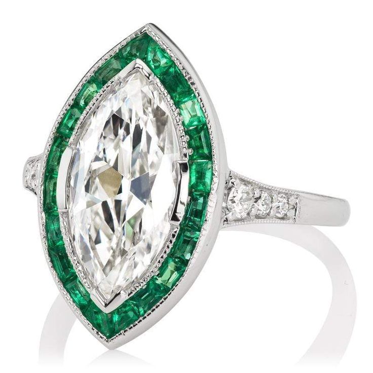 Marquise Diamond & Emerald Halo Engagement Ring The Gretchen 2.19 ring is an AB original design made right here in NYC. The ring centers a GIA-certified 2.19-carat Marquise cut diamond of G color, SI1 clarity. The stone is set in a platinum setting. Twenty carré cut emeralds are channel-set into a platinum halo surrounding the center stone with 3 old European cut diamonds set into each tapering shoulder. The ring is currently size 5.75 and can be resized! Why We Love It A stunning creation, if I Emerald Halo Engagement Ring, Art Deco Jewelry Rings, Victor Barbone Jewelry, Victor Barbone, Halo Engagement Ring Emerald, Emerald Halo, Marquise Diamond Engagement Ring, Vintage Art Deco Rings, Marquise Diamond Ring