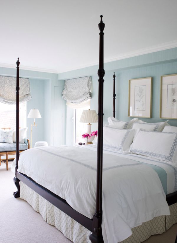 a bedroom with blue walls and white bedding in the center, along with two lamps on either side of the bed