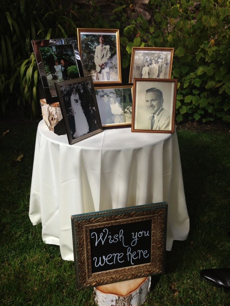 a table topped with pictures and framed photos next to a sign that says wish you