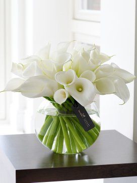 a vase filled with white flowers on top of a table