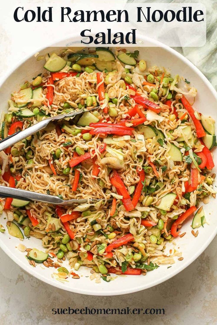 a white bowl filled with noodles and veggies on top of a marble table