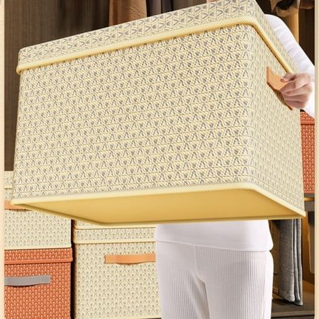 a woman holding a large mattress in front of some storage boxes and clothes on a shelf