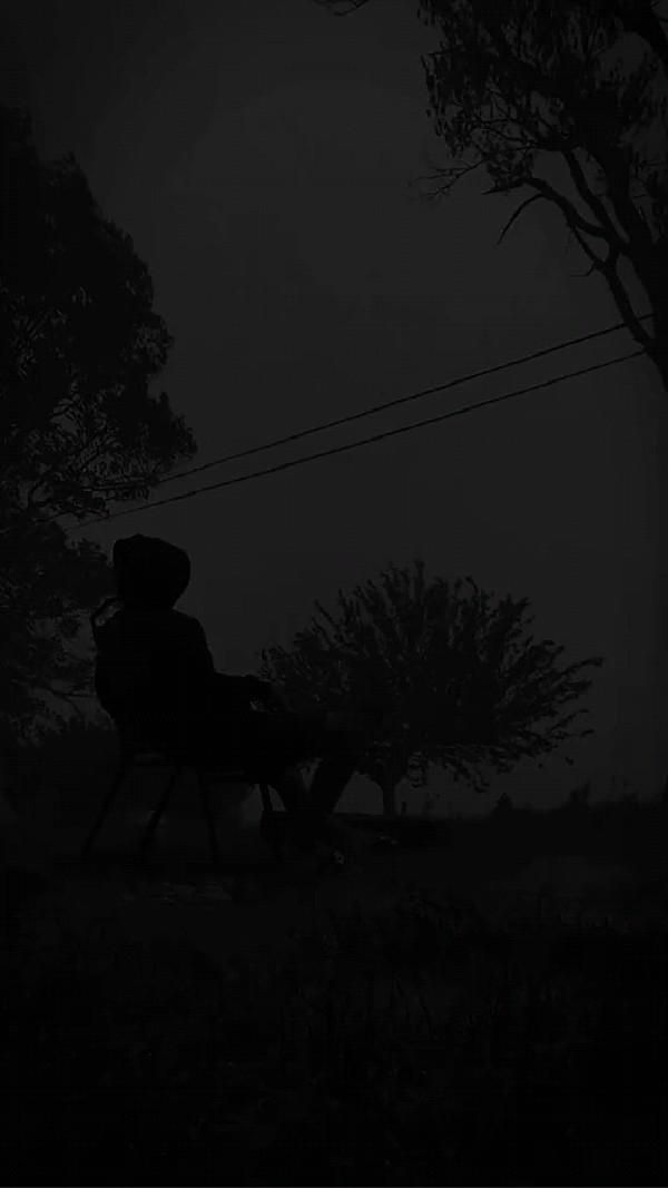 a person sitting on a bench in the dark