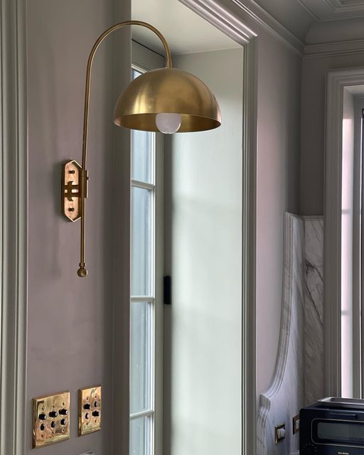 a bathroom with a toilet, mirror and light fixture in the corner next to it