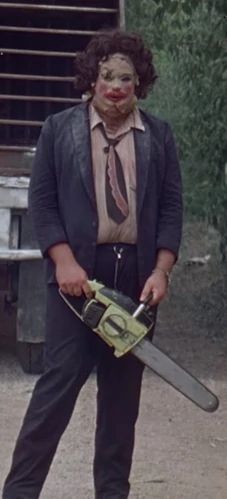 a clown holding a chainsaw in his hands