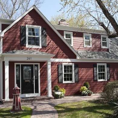 a red house with white trim and black shutters