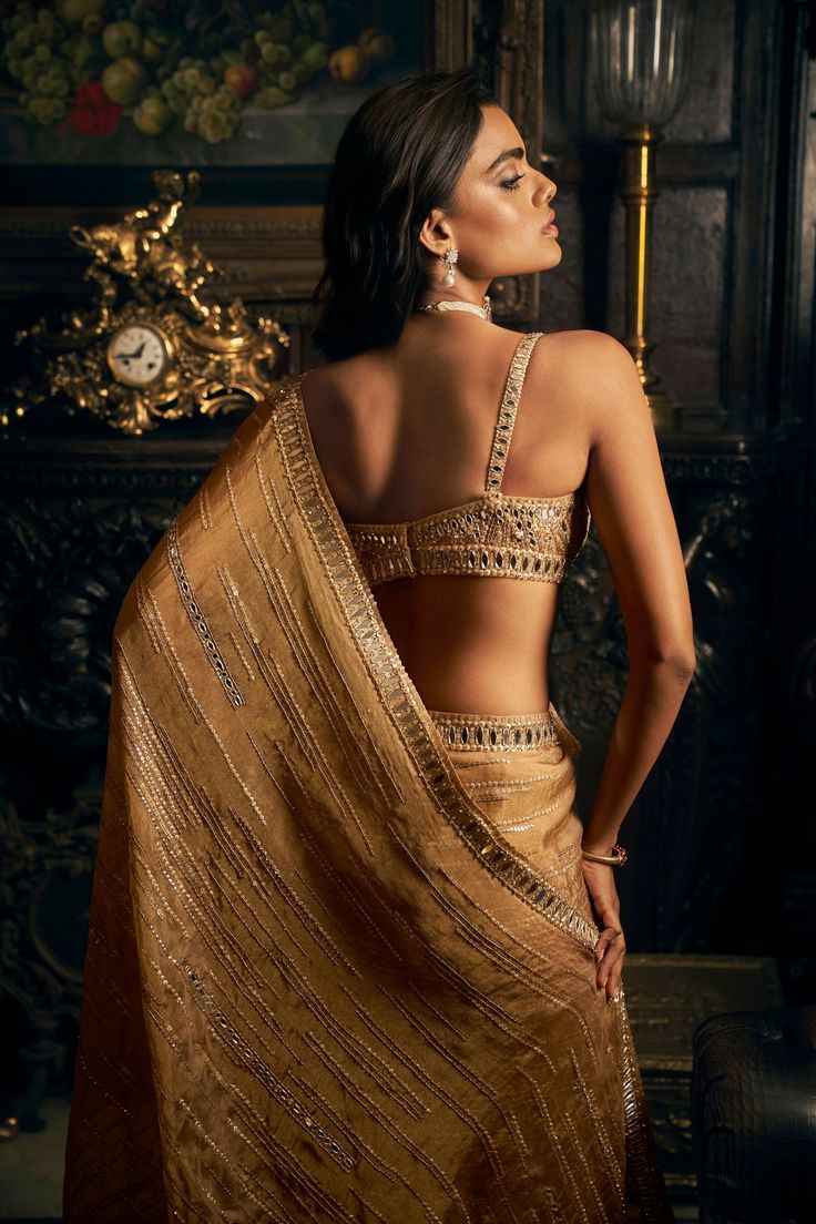 This organza tissue saree features mirror work embroidery in a linear pattern. It is paired with a matching embroidered strappy blouse.From Seema Gujral's Kashish collection DELIVERY TIMEPlease allow 8-12 weeks for your outfit to arrive. FABRIC DETAILSOrganza Professional cleaning only. Strappy Blouse, Mirror Work Embroidery, Skirt Set Outfit, Seema Gujral, Gold Organza, Mirror Work Saree, Saree Poses, Sari Dress, Tissue Saree