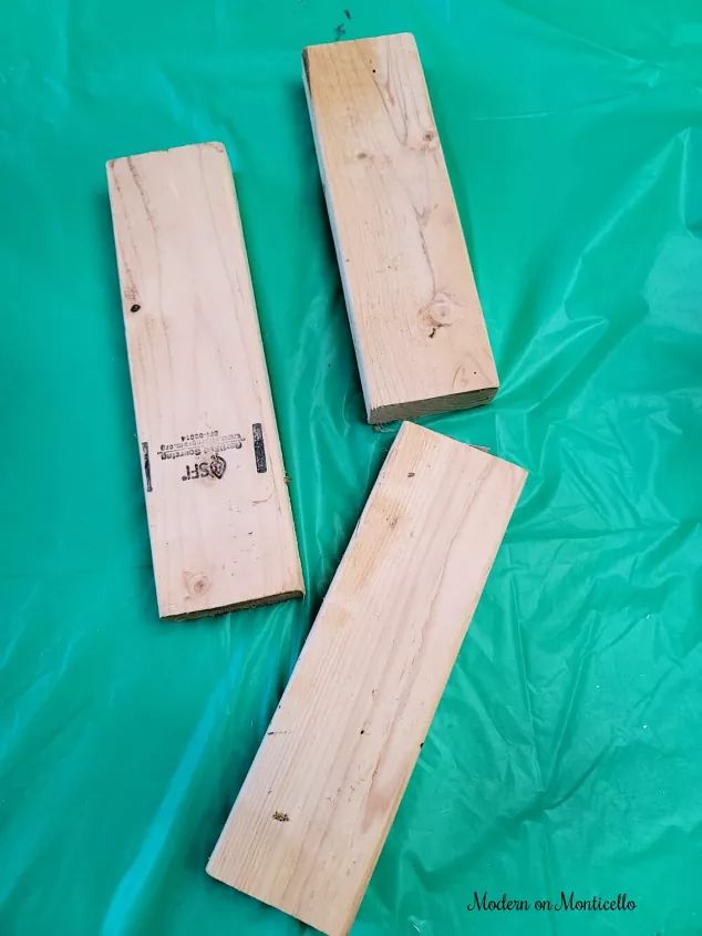 three pieces of wood sitting on top of a green sheet