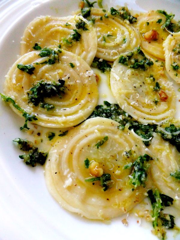 a white plate topped with pasta and spinach