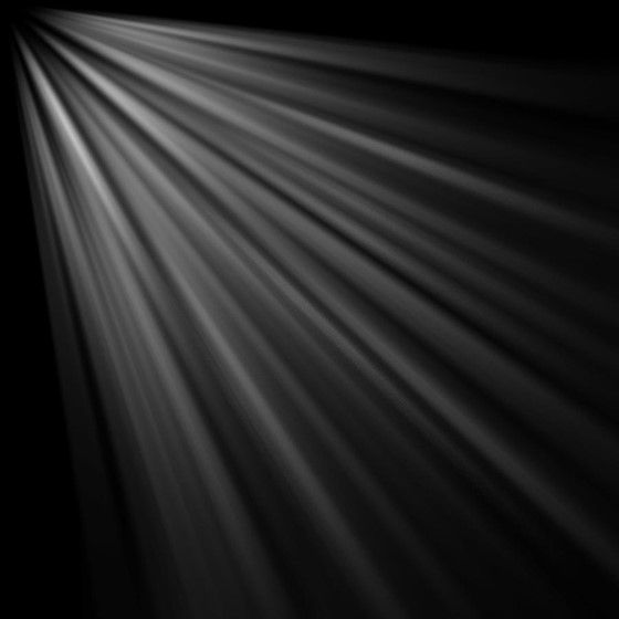 a black and white photo of light coming from the ceiling