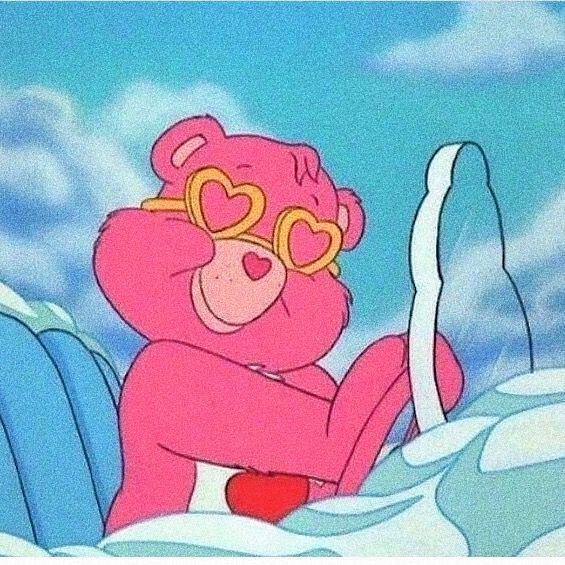 a pink teddy bear wearing heart shaped glasses