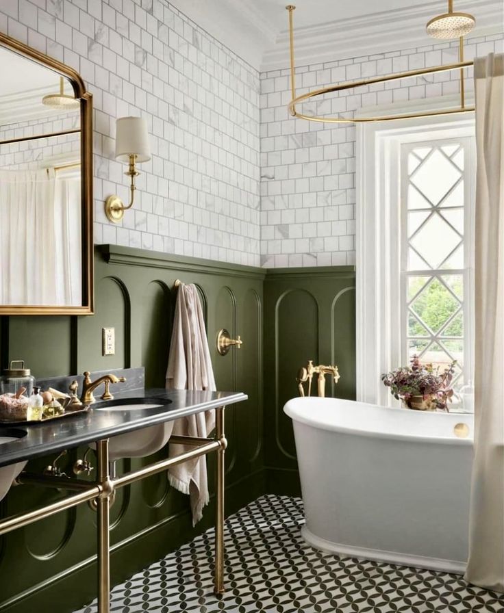 a bathroom with green walls and black and white flooring, gold fixtures and a claw foot tub