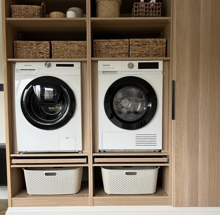 two washers are sitting next to each other in front of a shelf with baskets