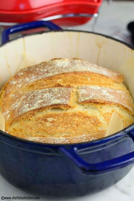 a loaf of bread in a blue casserole dish on a white counter top