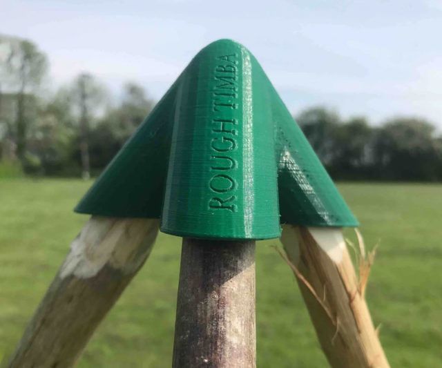 a close up of a wooden post with a green top