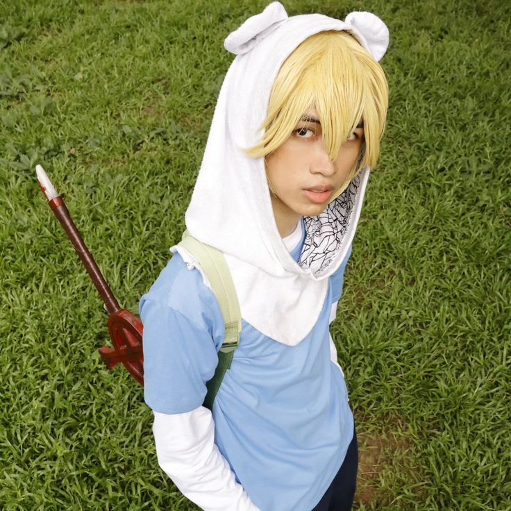 a young man dressed up as an anime character with a bow and arrow in his hand