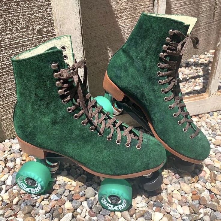 a pair of green roller skates sitting on top of gravel