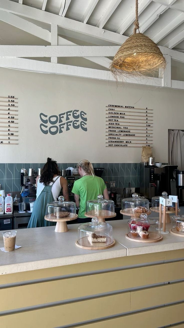 people are standing at the counter in a coffee shop