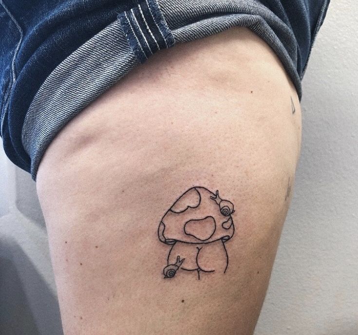 a small mushroom tattoo on the thigh