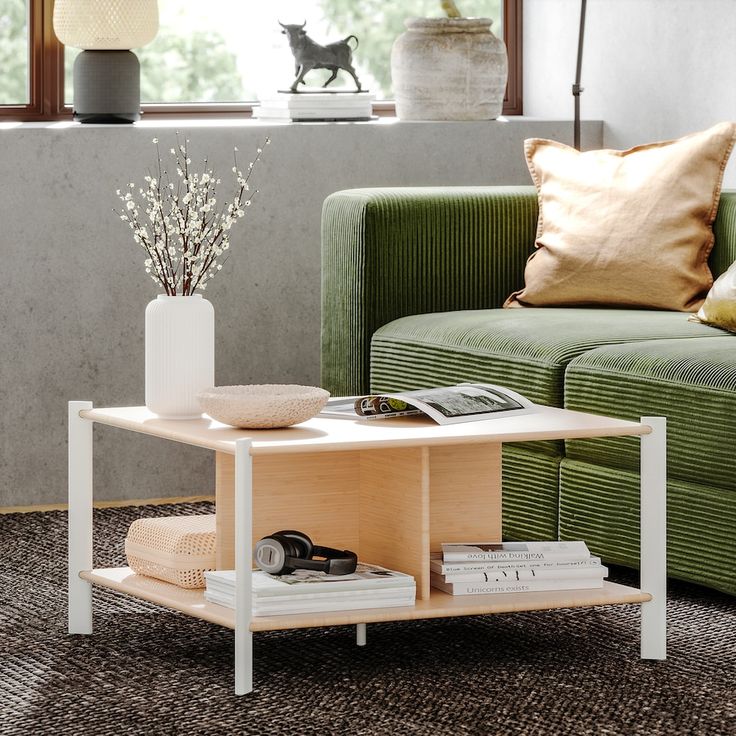 a living room with green couches and a coffee table in front of a window