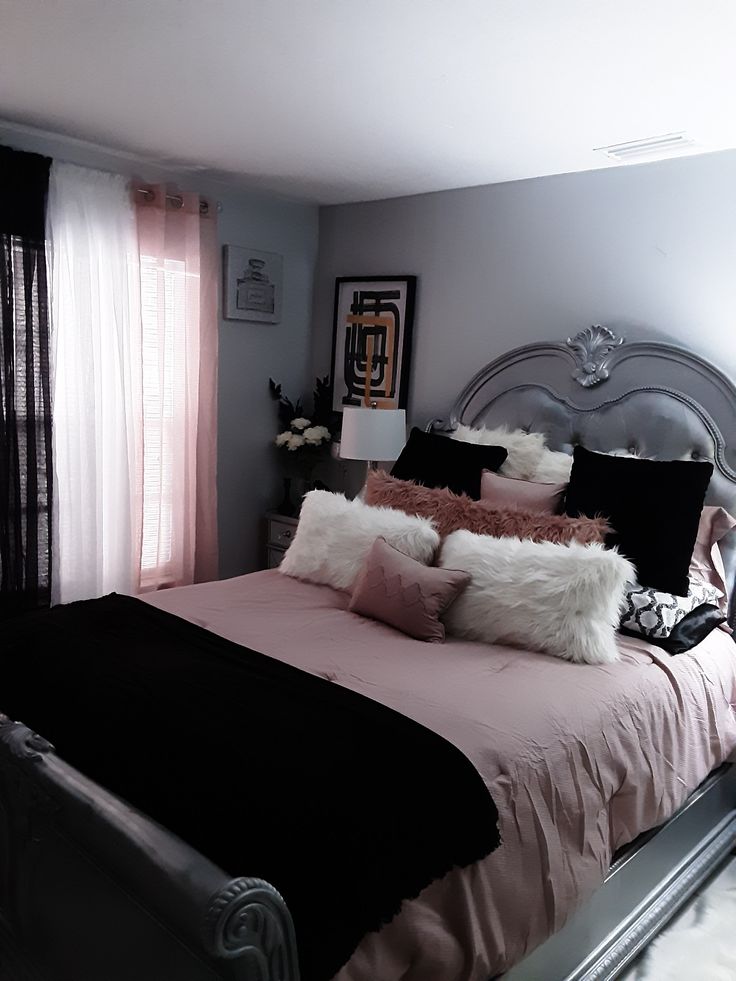 a bed with pink and black pillows in a bedroom