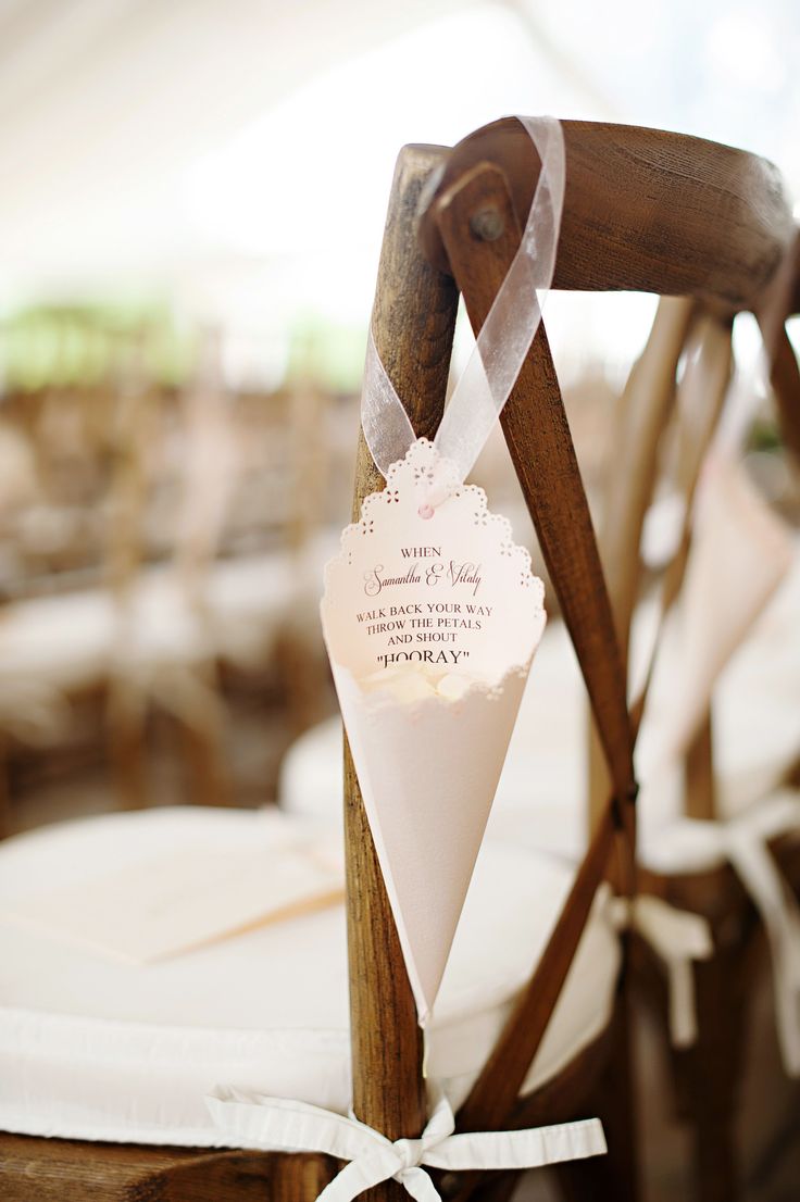 the back of a wooden chair with a white ribbon on it