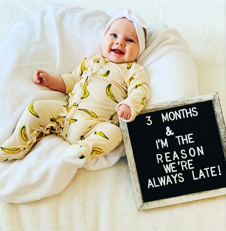 a baby is laying down next to a sign that says 3 months and i'm the reason we're always late