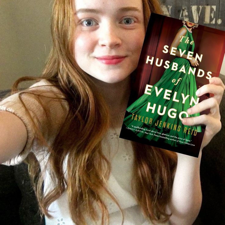 a girl holding up a book in front of her face